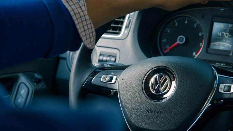 Hombre al volante de coche Volkswagen desinfectado ante COVID-19