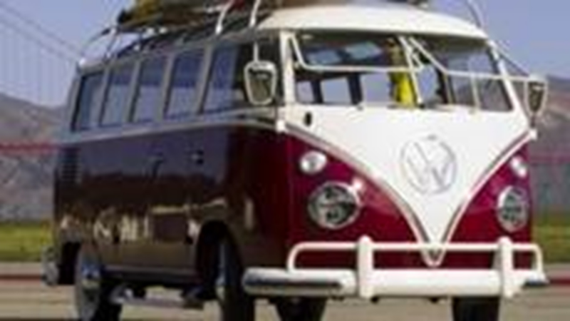 Schuin vooraanzicht van een oude Volkswagen bus in rood wit