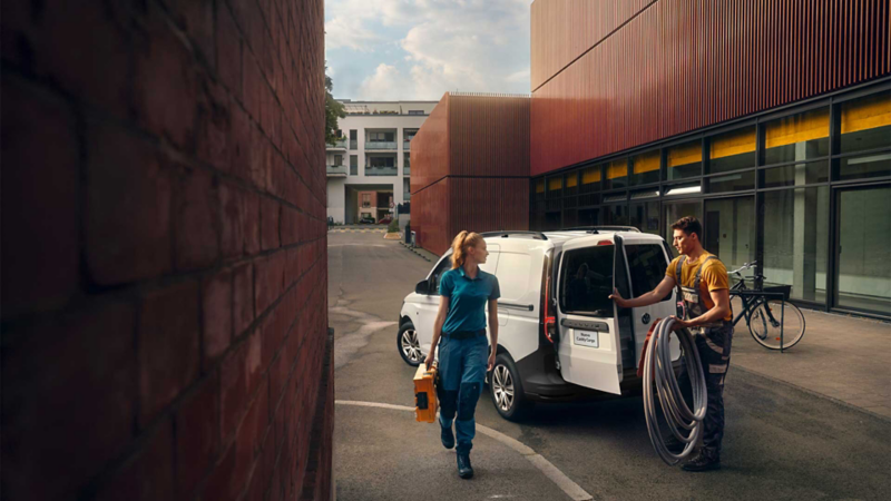 Trabajadores descargan herramientas de una van Nuevo Caddy de Volkswagen.