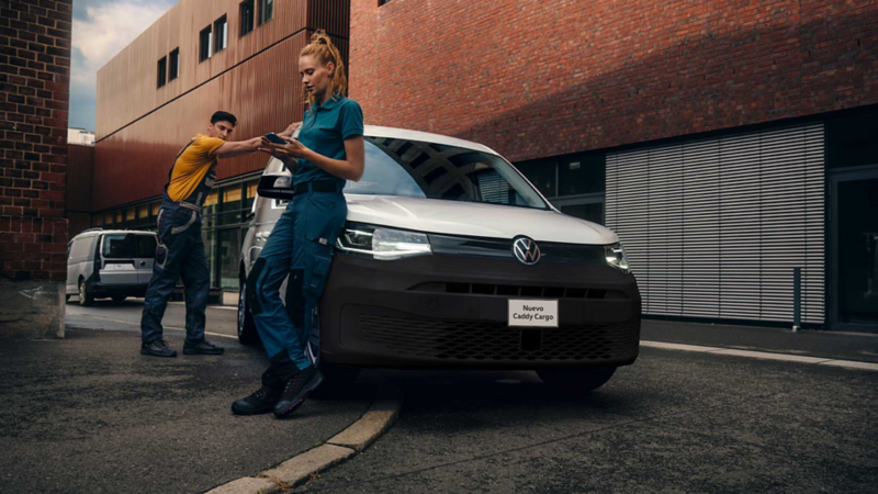 Volkswagen Caddy en color blanco, con trabajadores recargados sobre la versión Cargo. 
