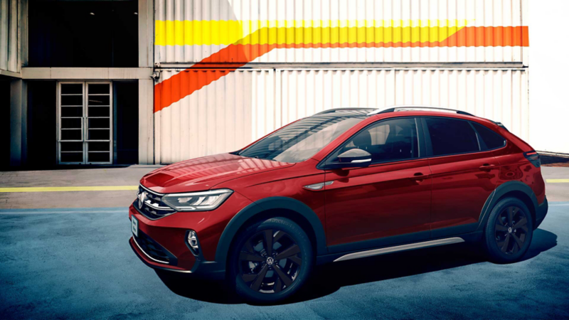 Nivus 2022 Highline color rojo - Camioneta SUVW estacionada frente a edificio con pared de lámina blanca. 