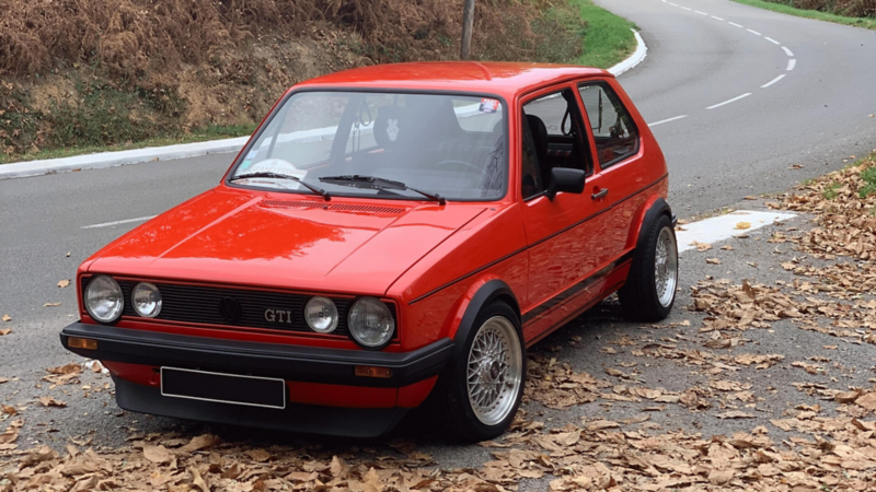 Golf GTI rouge customisée stationnée sur le bord de la route