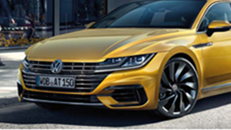 Schuin vooraanzicht van een gele Volkswagen Arteon die buiten staat