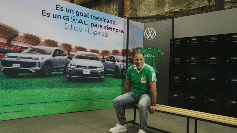 Alberto García Aspe sentado en una banca frente a imagen conmemorativa de lanzamiento de GOAL.