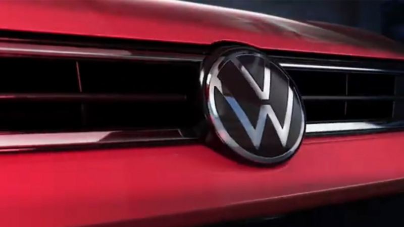 Emblema de Volkswagen en auto sedán 2022, color rojo. 