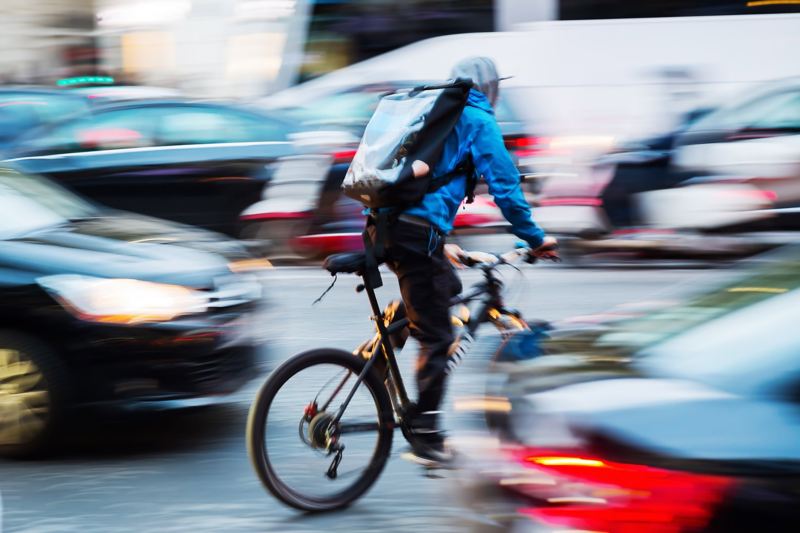 Ein Fahrradkurier schlängelt sich durch den dichten Stadtverkehr