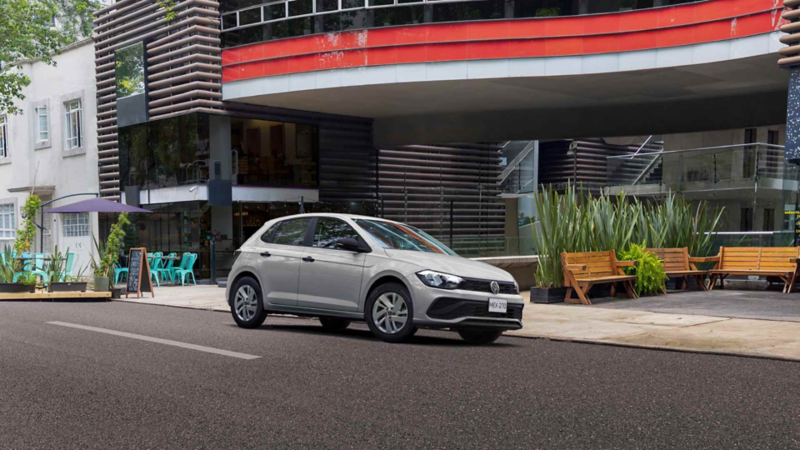 Volkswagen Polo Track de color gris. Vista frontal en tres cuartos, estacionado frente a locales comerciales.