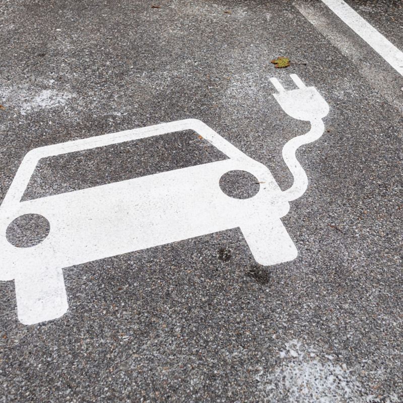 Eine Bodenmarkierung in Form eines Autos mit Ladekabel zeichnet den E-Parkplatz aus