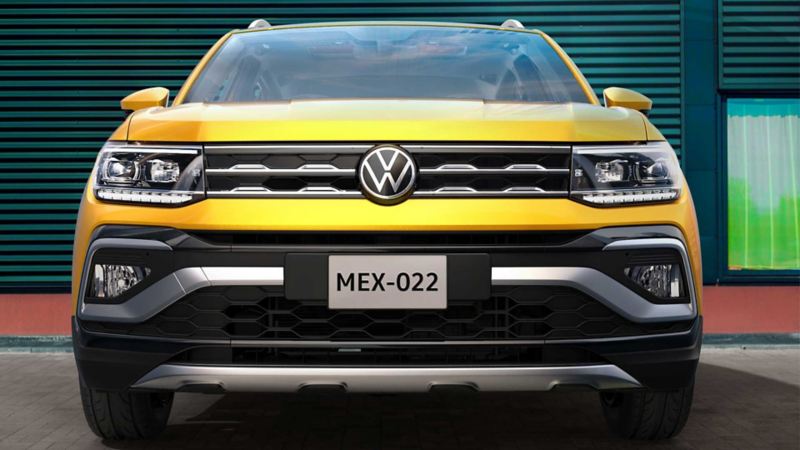 Parrilla de Nuevo T Cross 2022 con logo VW al frente, camioneta en color amarillo.