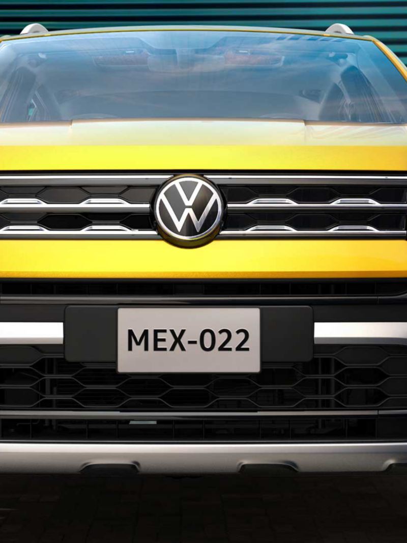 Parrilla de Nuevo T Cross 2022 con logo VW al frente, camioneta en color amarillo.