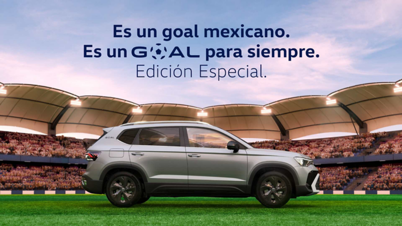 Volkswagen Taos GOAL en color gris dentro de una cancha de futbol. 