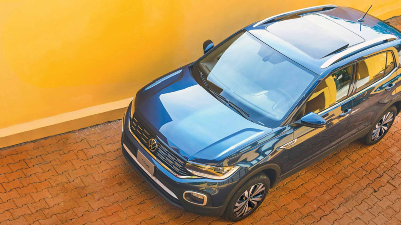 Camioneta T Cross Volkswagen edición 2022 en color azul, cerca de pared amarilla. 