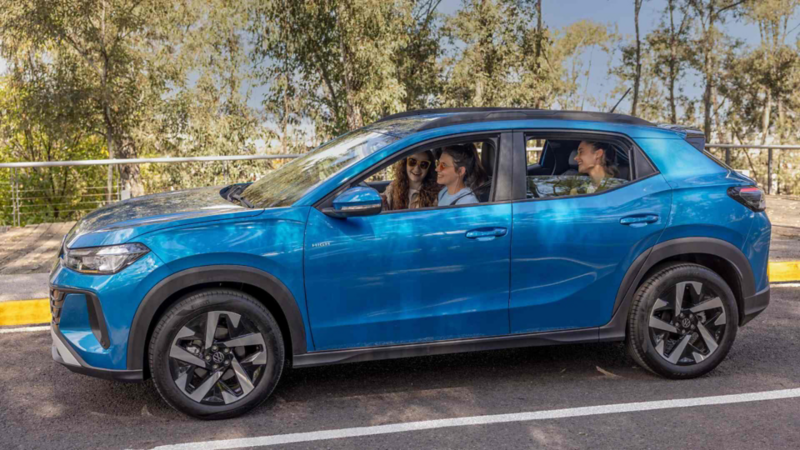 Volkswagen Tera. Vista lateral de SUV de color azul en movimiento con tres mujeres en el interior.