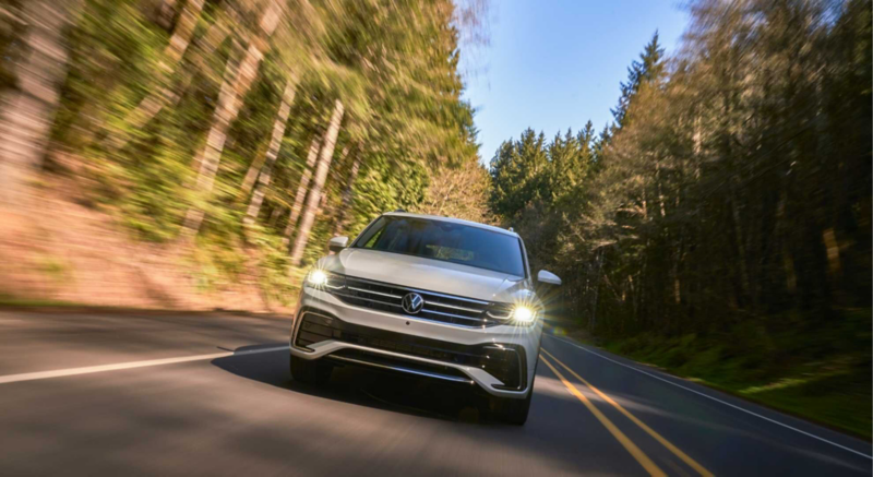 Nueva camioneta familiar Tiguan VW en carretera rodeada de bosque