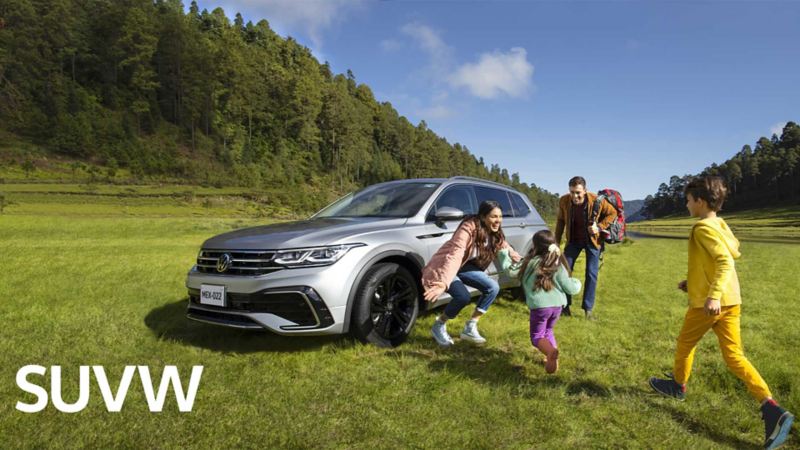 Camioneta familiar Nuevo Tiguan 2022 de Volkswagen con familia que se divierte en un bosque. 