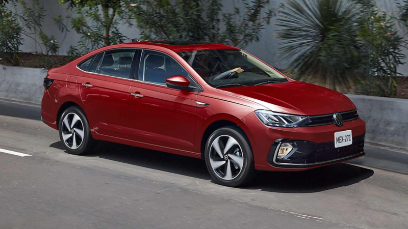 Volkswagen Virtus. Vista lateral de sedán rojo que circula sobre una avenida con un camellón arbolado.Modificado con inteligencia artificial