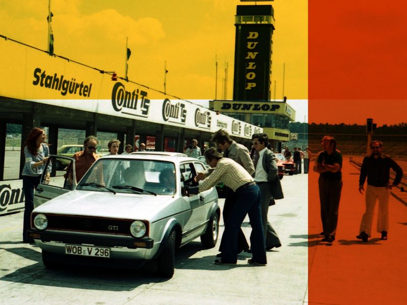 A retro image of a VW MK1. Several people are observing the car