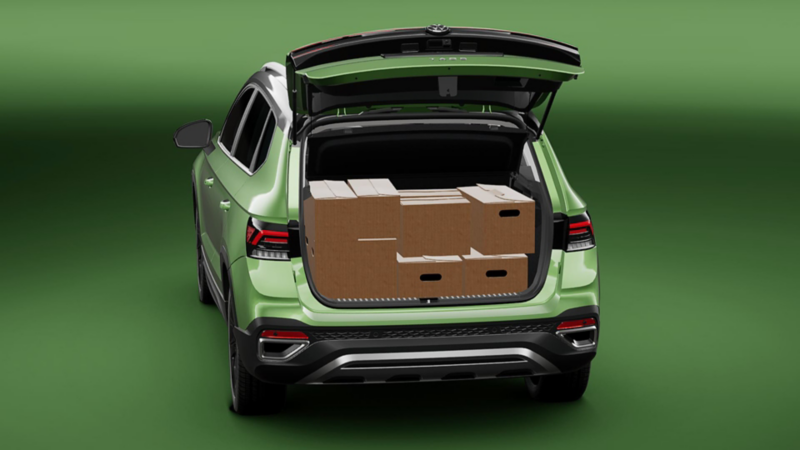 Volkswagen Taos. Vista trasera de SUV de color verde con cajuela abierta llena de cajas de cartón.