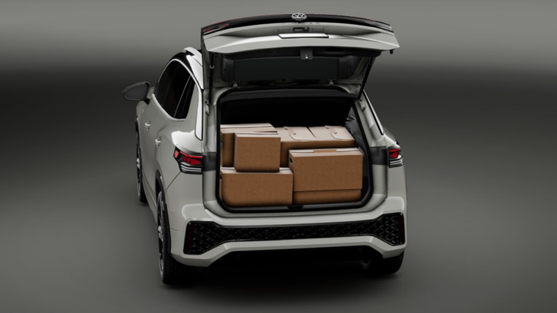 Volkswagen Tiguan. Vista trasera de SUV de color gris con cajuela abierta llena de cajas de cartón.