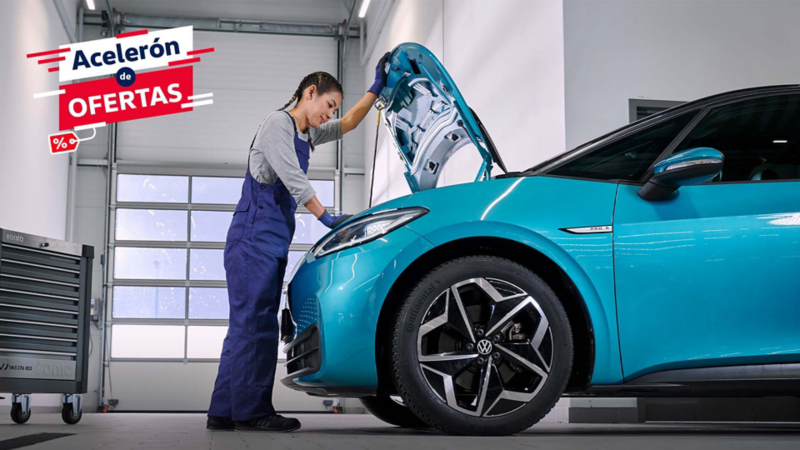 Mecánica experta realiza inspección de motor en auto VW durante servicio.