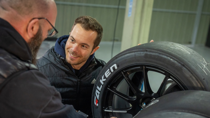 Benjamin «Benny» Leuchter spricht mit einem Mechaniker über Rennreifen von Falken Motorsport.