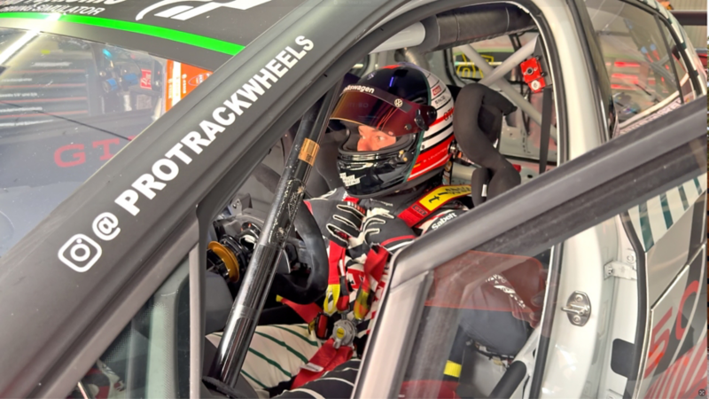 Benjamin «Benny» Leuchter assis dans le cockpit d’une voiture de course Volkswagen en train d’enfiler ses gants.
