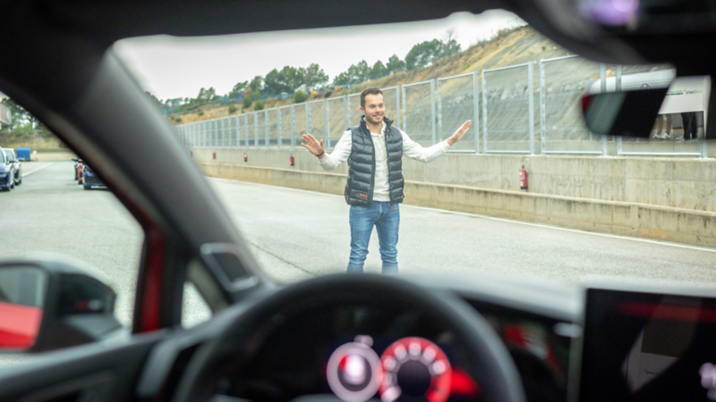 Vue depuis le cockpit d’une voiture vers Benjamin «Benny» Leuchter debout dans la voie des stands.