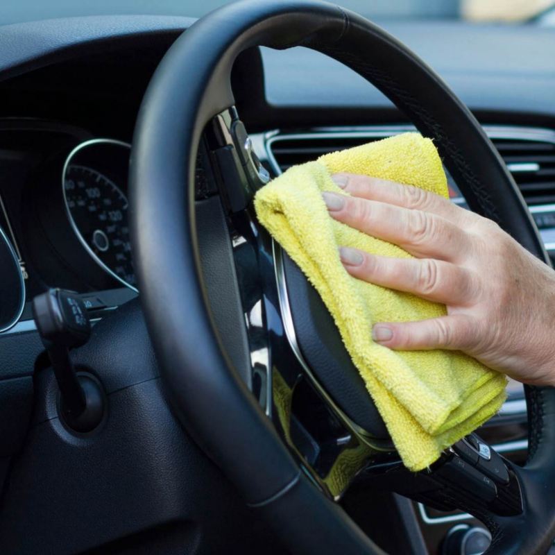 Imagen de muestra a una mujer limpiando el volante de su auto Volkswagen.