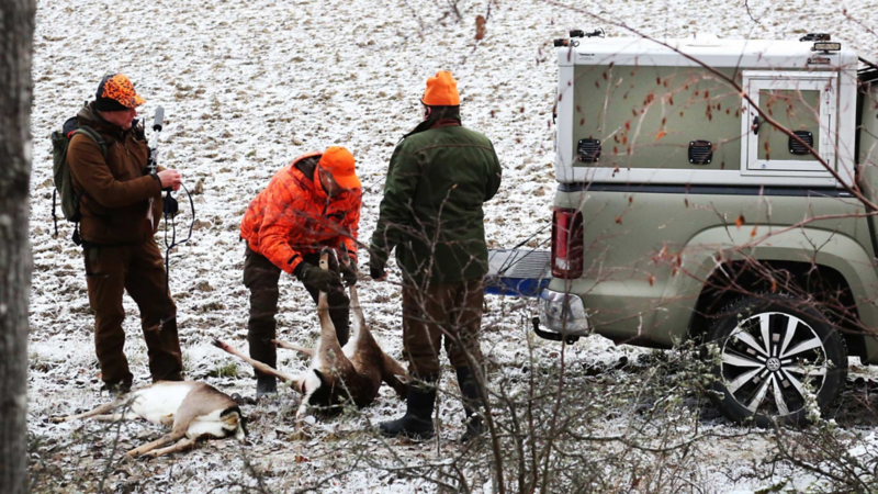 Jägare med byte vid den för jakt specialbyggda VW Amarok