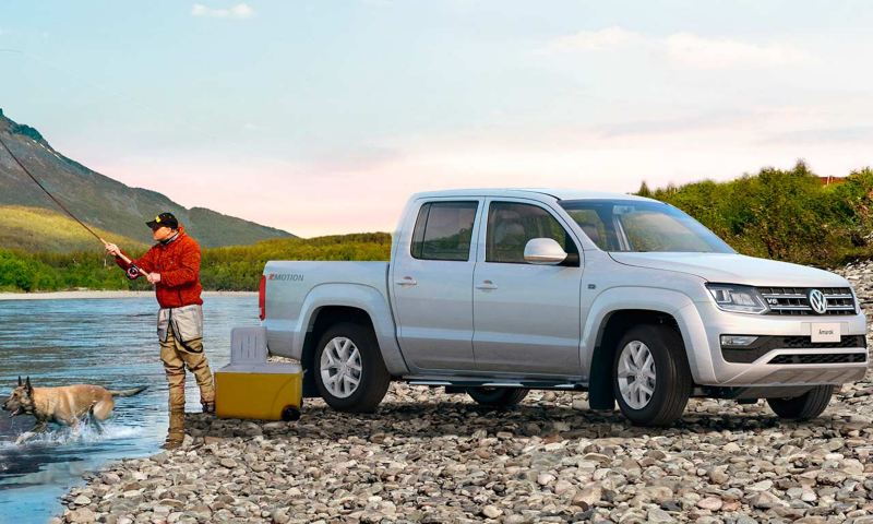 Pick up Amarok Volkswagen - Camioneta 4x4 en color gris cerca de un hombre que pesca.