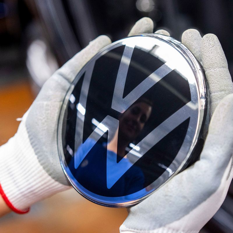 Una donna tiene fra le mani il logo Volkswagen