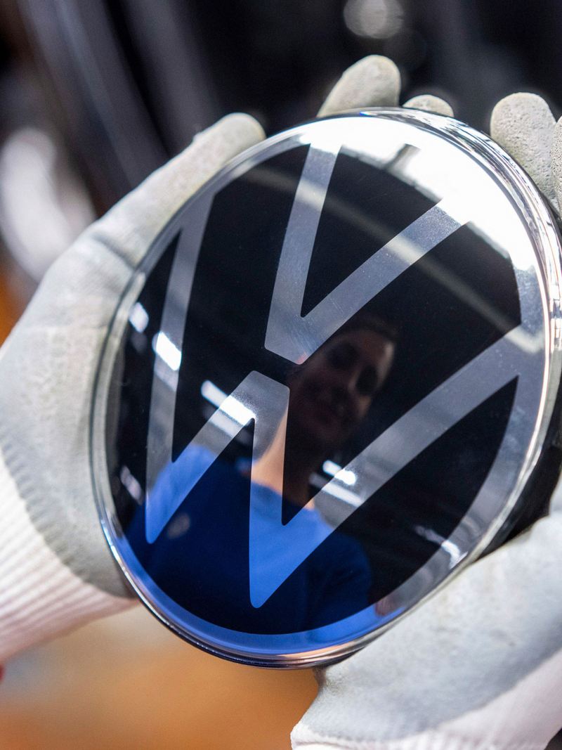 Una donna tiene fra le mani il logo Volkswagen