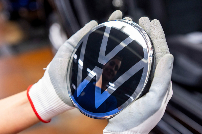 Una donna tiene fra le mani il logo Volkswagen