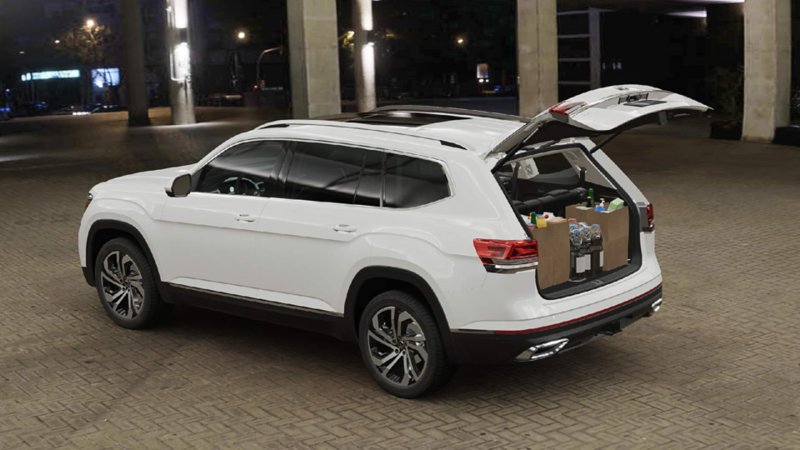 Camioneta SUV Cross Sport de color blanco, con cajuela abierta y llena de despensa. 
