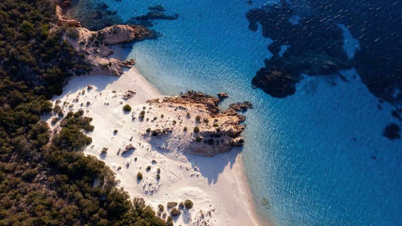 Vit sandstrand och klarblått vatten vid Costa Smeralda.