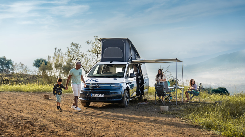 Eine Familie hat Ihren VW California geparkt und aufgebaut.