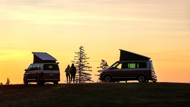 Två VW California 6.1 står i solnedgången med popuptak uppfällda.