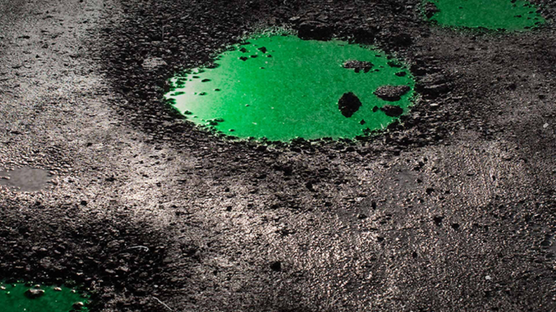 Baches en las calles con un charco de tono verde.