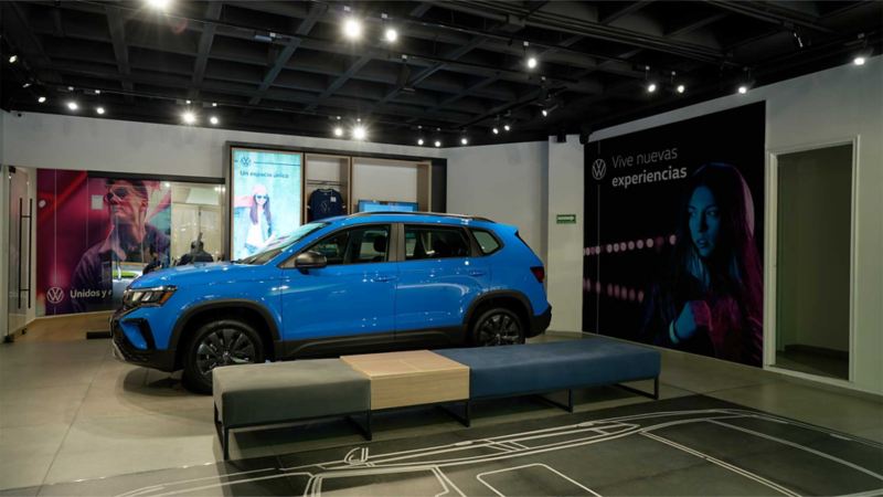 Interior de la nueva agencia Volkswagen City Store Condesa, con camioneta Taos 2022 en color azul. 