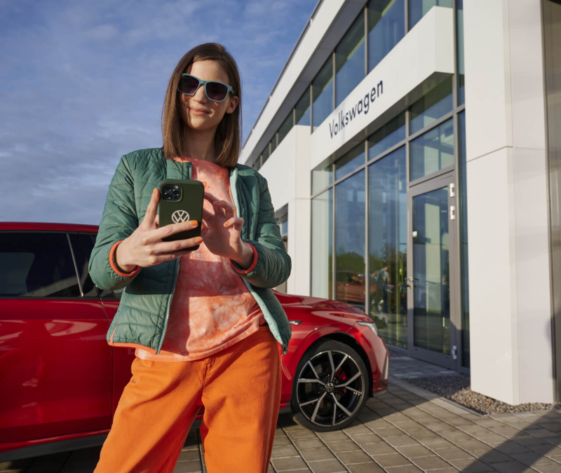 Imagen de una mujer con gafas de sol ultilizando su celular para contactar a VW en Ecuador