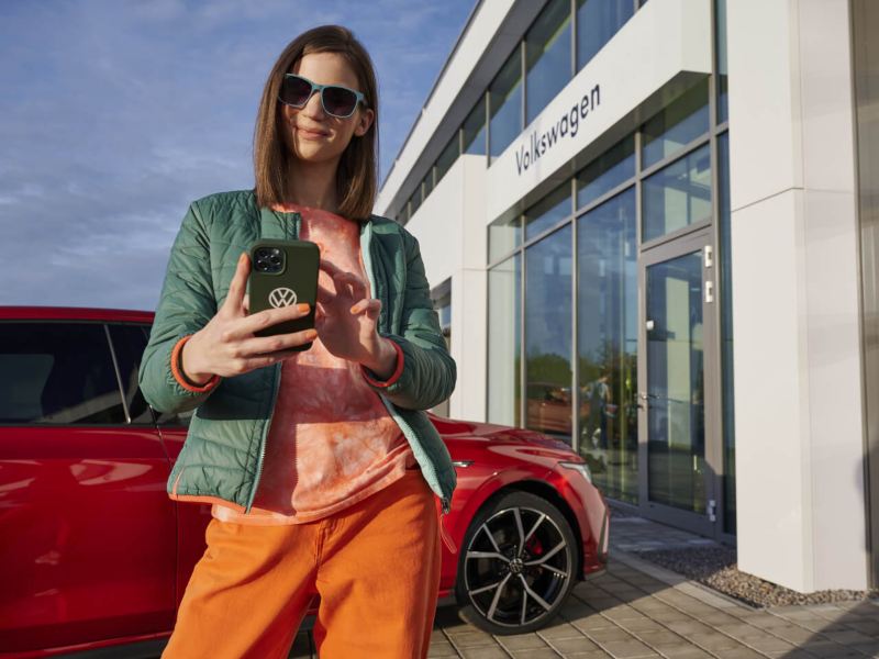 Imagen de una mujer con gafas de sol ultilizando su celular para contactar a VW en Ecuador
