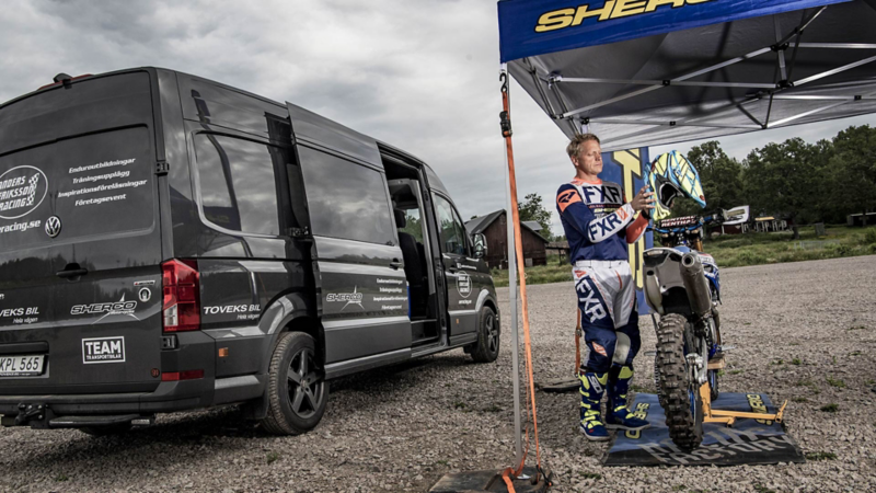 Världsmästaren i enduro, Anders Eriksson, framför sin arbetsbil VW Crafter Skåp