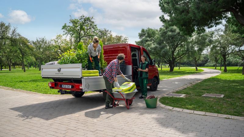 En röd VW Crafter Chassi stor flakbil som används för trädgårdsarbete