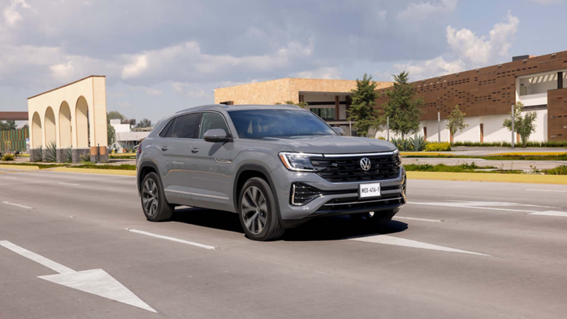 Volkswagen Cross Sport en color exterior gris circula sobre avenida amplia. 