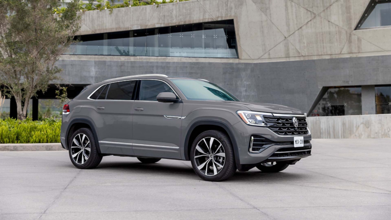 Camioneta Cross Sport de Volkswagen, en color gris. Modelo 2026 estacionado a las afueras de un teatro. 