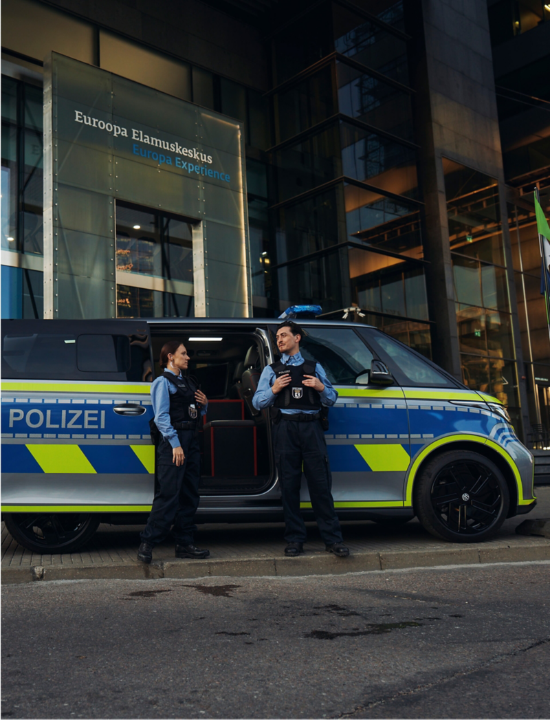 Zwei Polizisten stehen vor einem VW ID. Buzz mit Umbau zum Einsatzwagen.