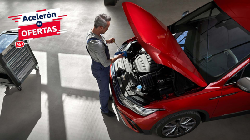 Mecánico experto realiza inspección de motor en auto VW rojo durante servicio.