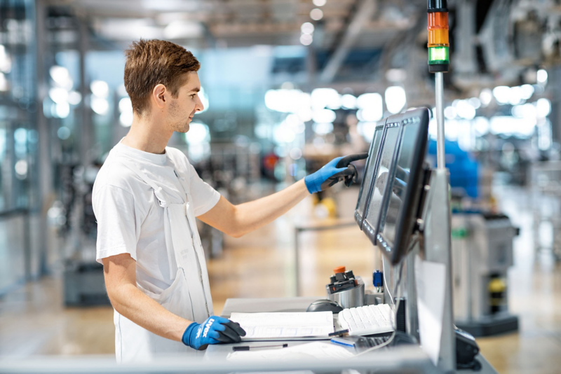 Ein Fachmann prüft im VW Werk eine Einstellung an einem Display
