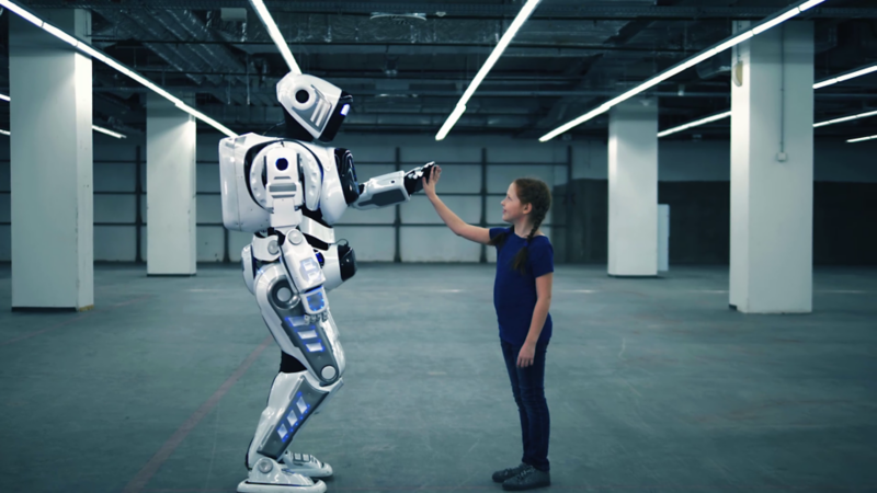 Dziewczynka przybija piątkę z robotem.