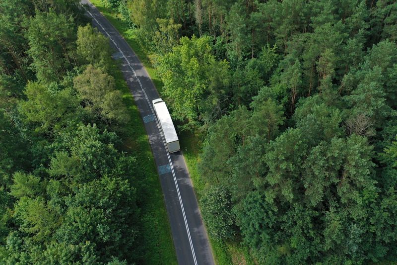 Lastkraftwagen von oben gesehen auf einer Straße durch Wald